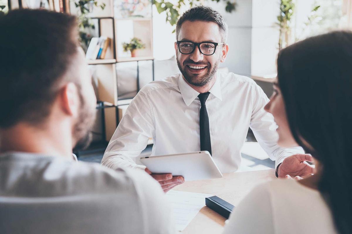 Banquero sonriendo a una pareja
